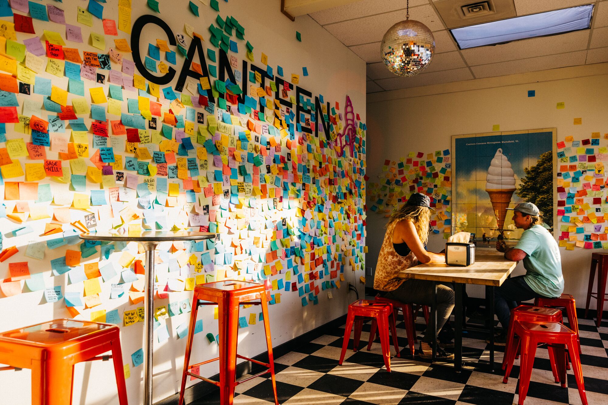 Two people sitting at a table in an ice cream shop.