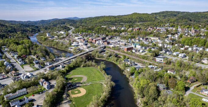 Aerial view of a small town among green hills.