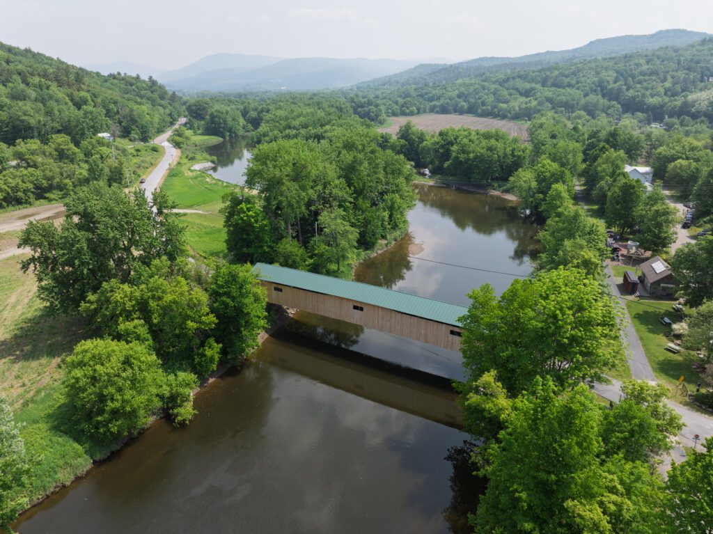 Aerial view of a long wooden covered bridge in Vermont.