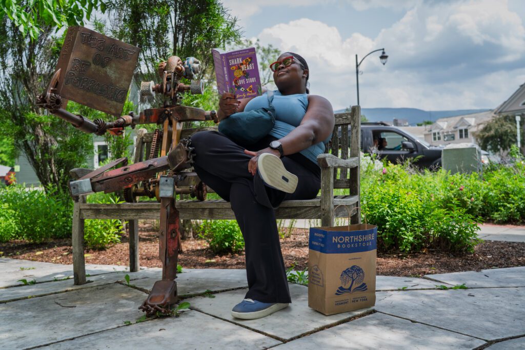 A woman reads a book on a bench outside Northshire Bookstore in Manchester, Vermont.