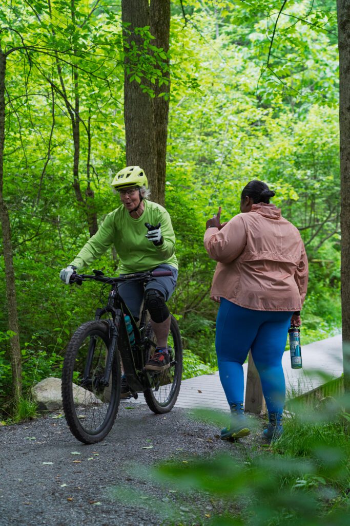 A woman walking meets a cyclist on a bike path in Vermont.