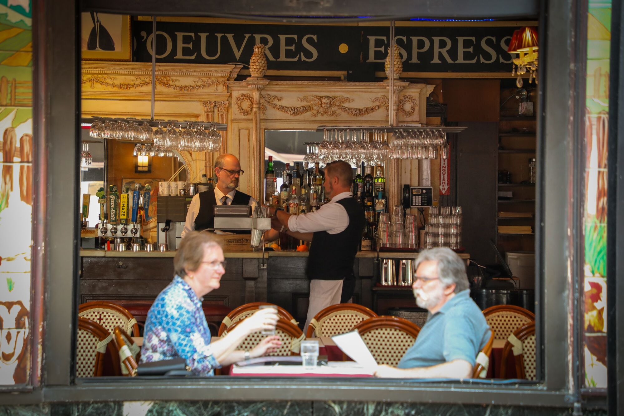Two people look at menus at an outdoor restaurant in Vermont.