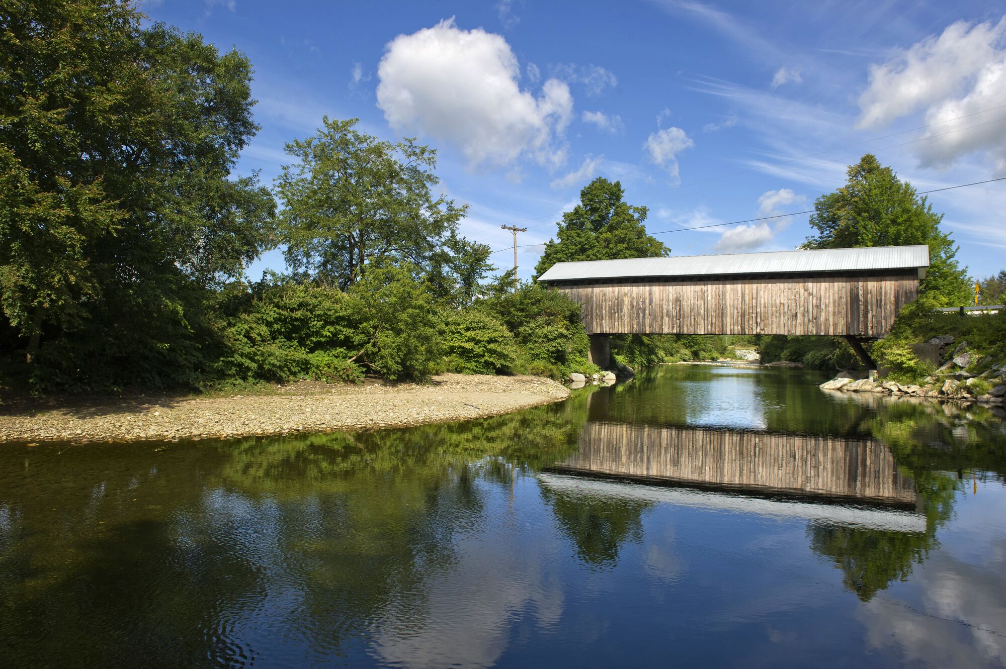 A covered bridge crosses a river in Vermont.