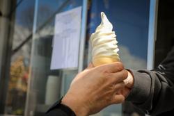 A person is handed a maple creemee ice cream cone in Vermont.