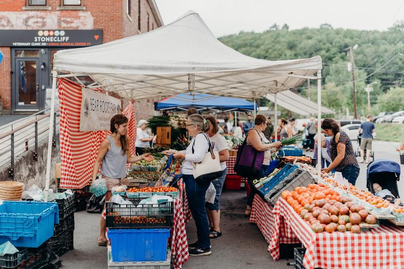 A vendor and a customer interact at a farmer's market in Vermont.