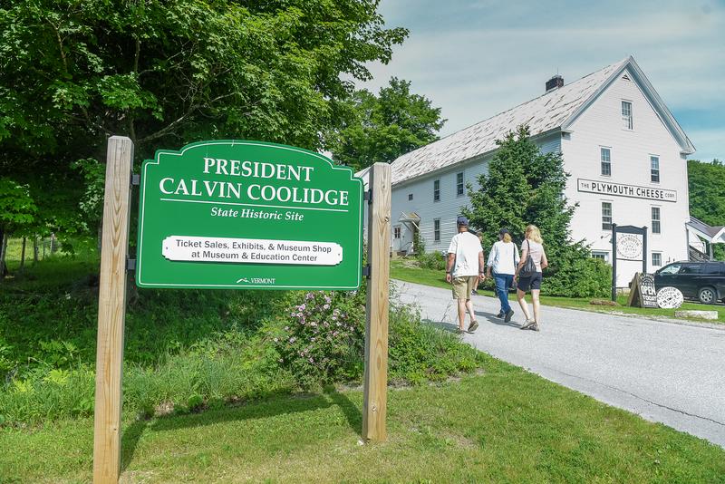 Three people walk toward a historic building in Vermont.