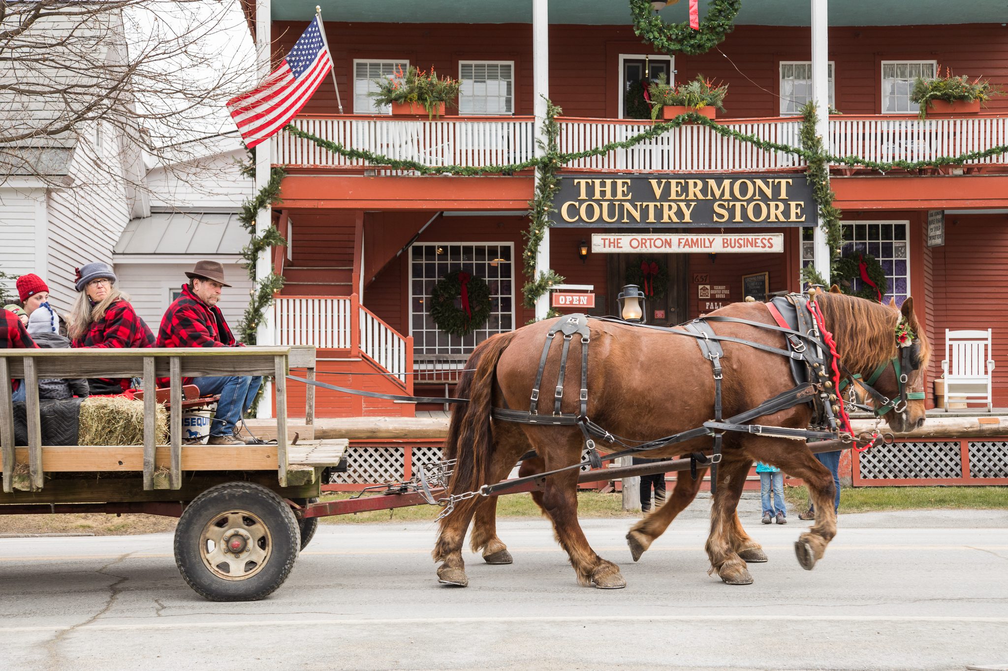 A horse-drawn carriage passes a country store in Vermont.