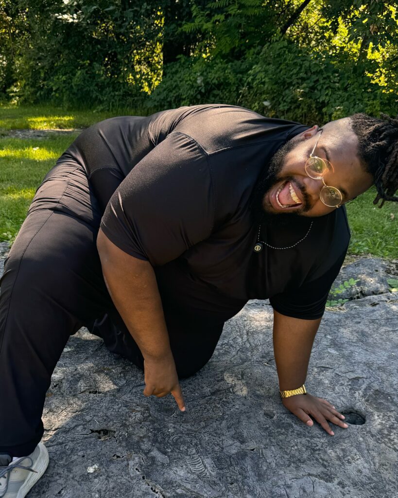 A person points at a fossil imprint on a rock.