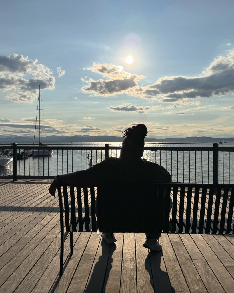 A person sits on a bench on a dock.