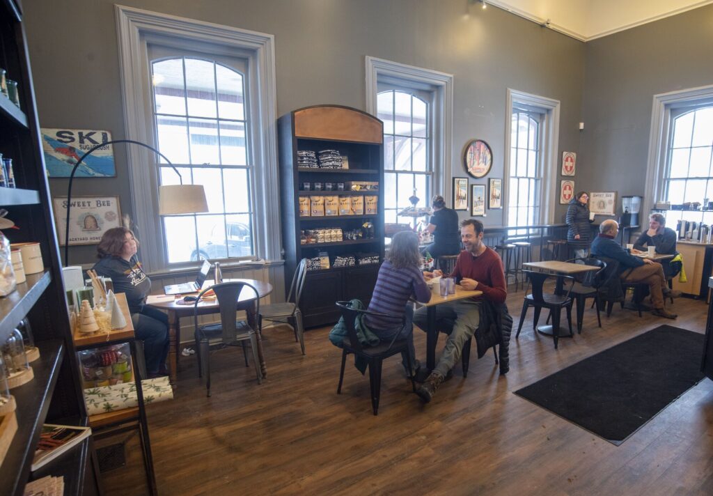People sit at a small table in a coffee shop.