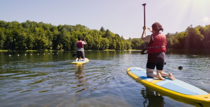 Two people on paddleboards on a reservoir in Vermont.