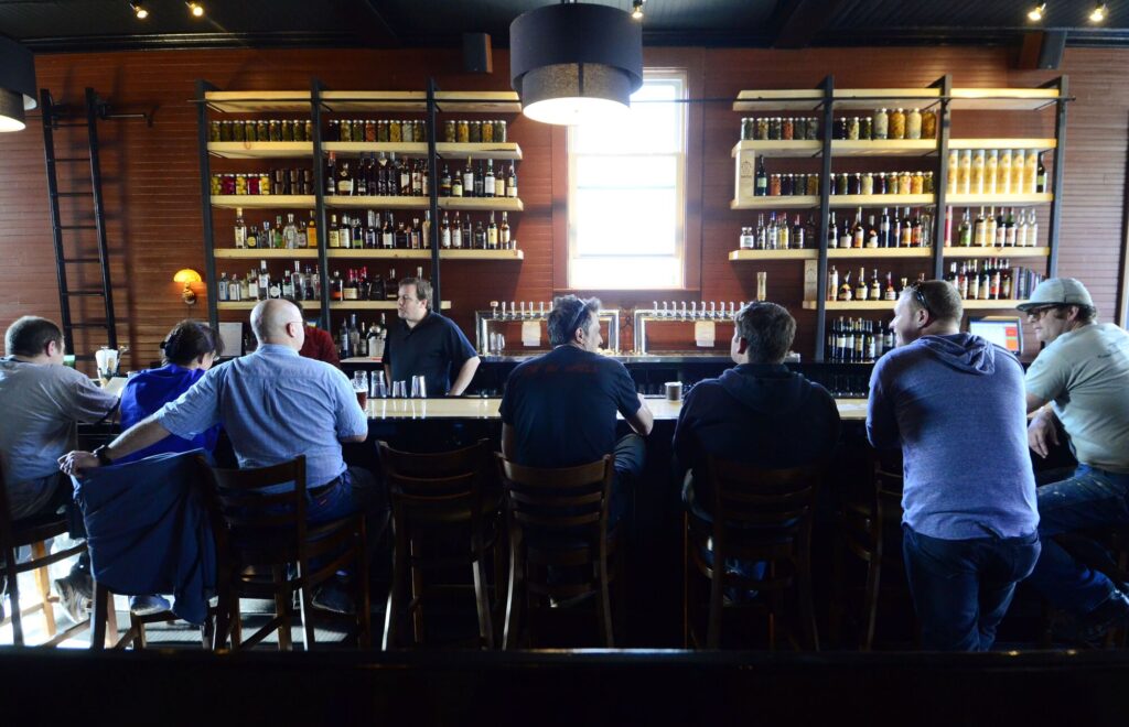 Patrons sit at a bar.