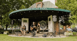 Musicians play at an outdoor pavilion.