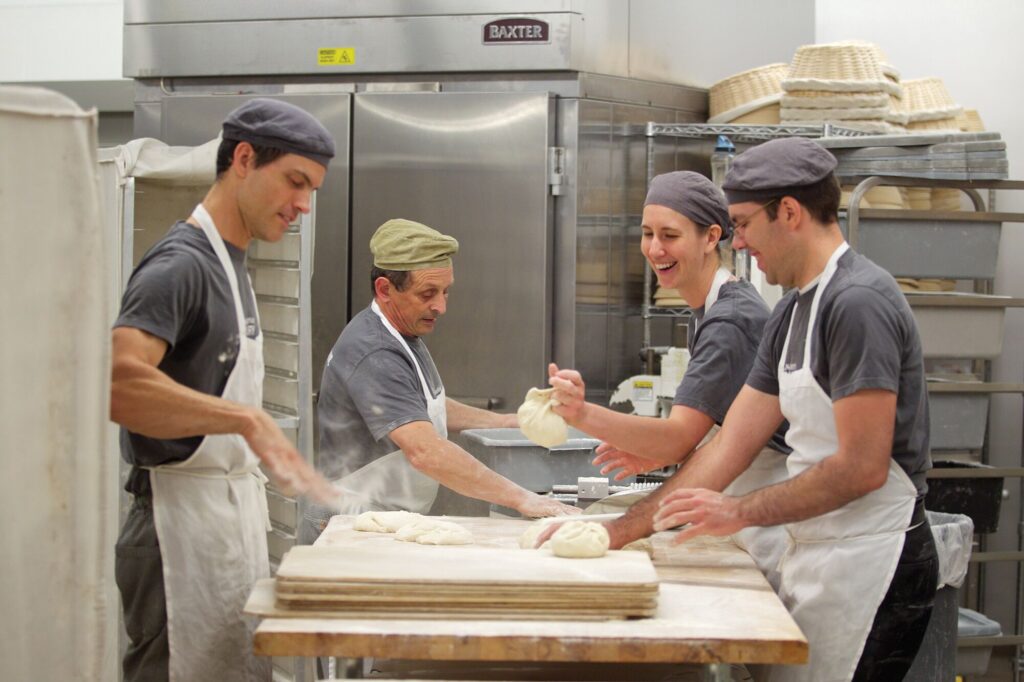 Three people make bread at King Arthur Baking in Vermont.