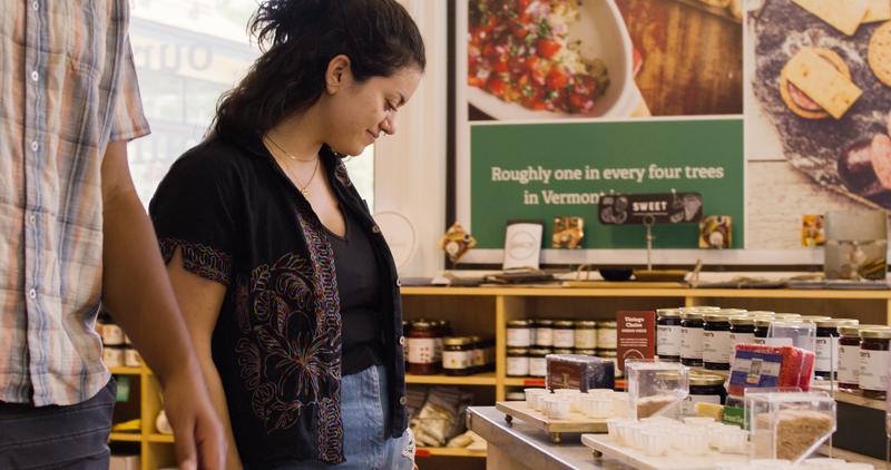 A person samples cheese at a store in Vermont.