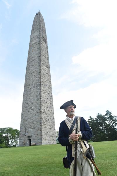 A person dressed in Revolutionary War costume in front of the Bennington Battle Monument in Vermont.