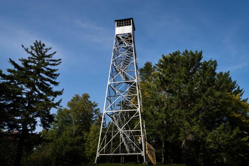 A fire tower seen from outside and from the base looking up on a summer sunny day.