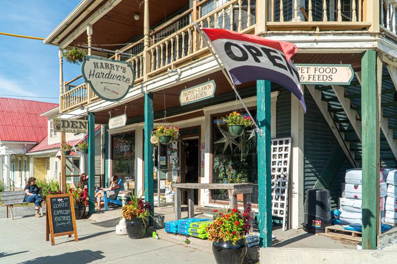 The exterior storefront of a rustic, multi-story country store with a sign that reads 