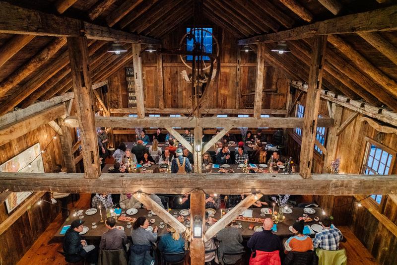 Seen from above, people in a pub enjoying food and drink.