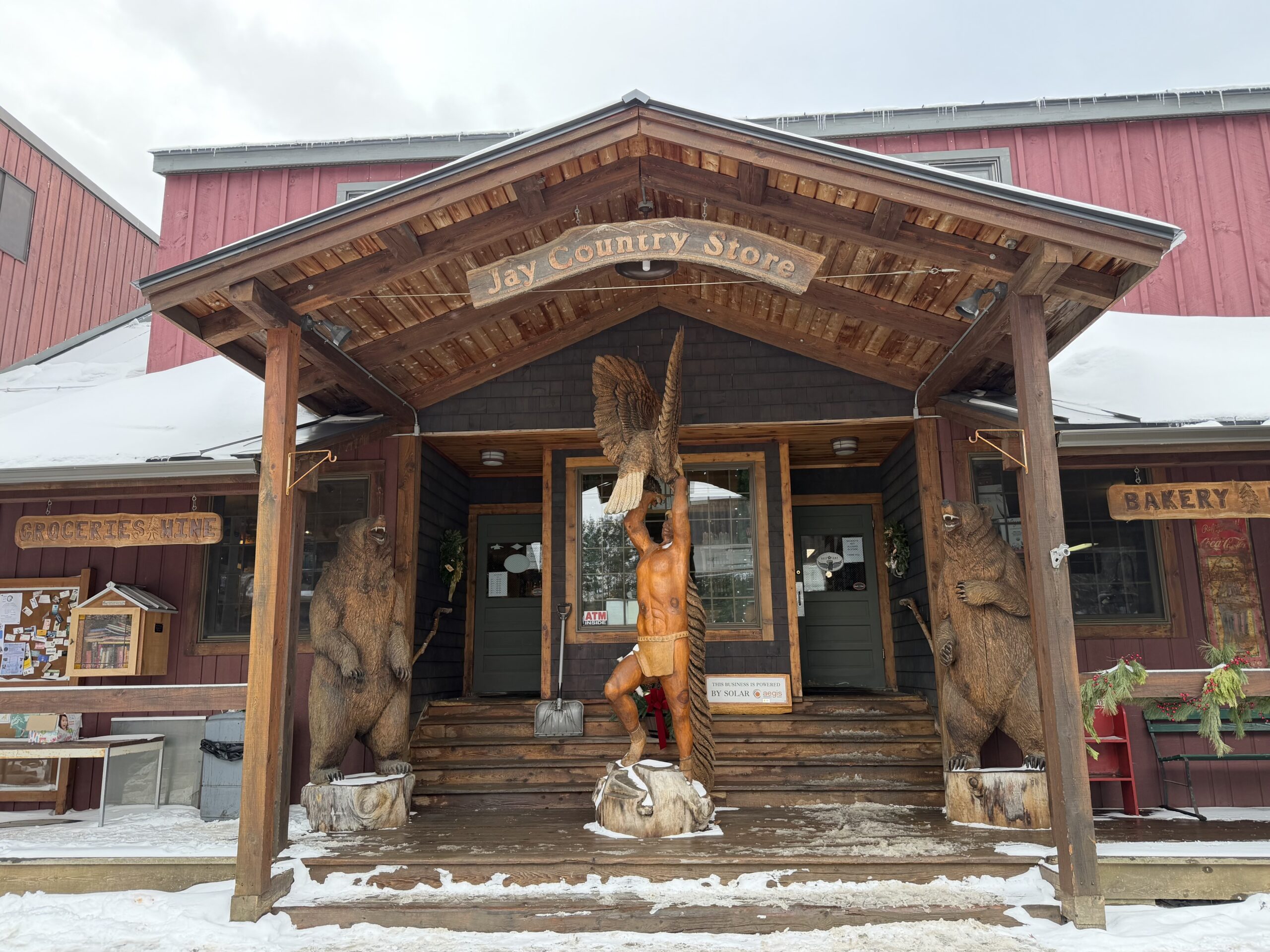 The outside of a general store with a sign reading “Jay Country Store.” The exterior is wood with ornate carvings. 